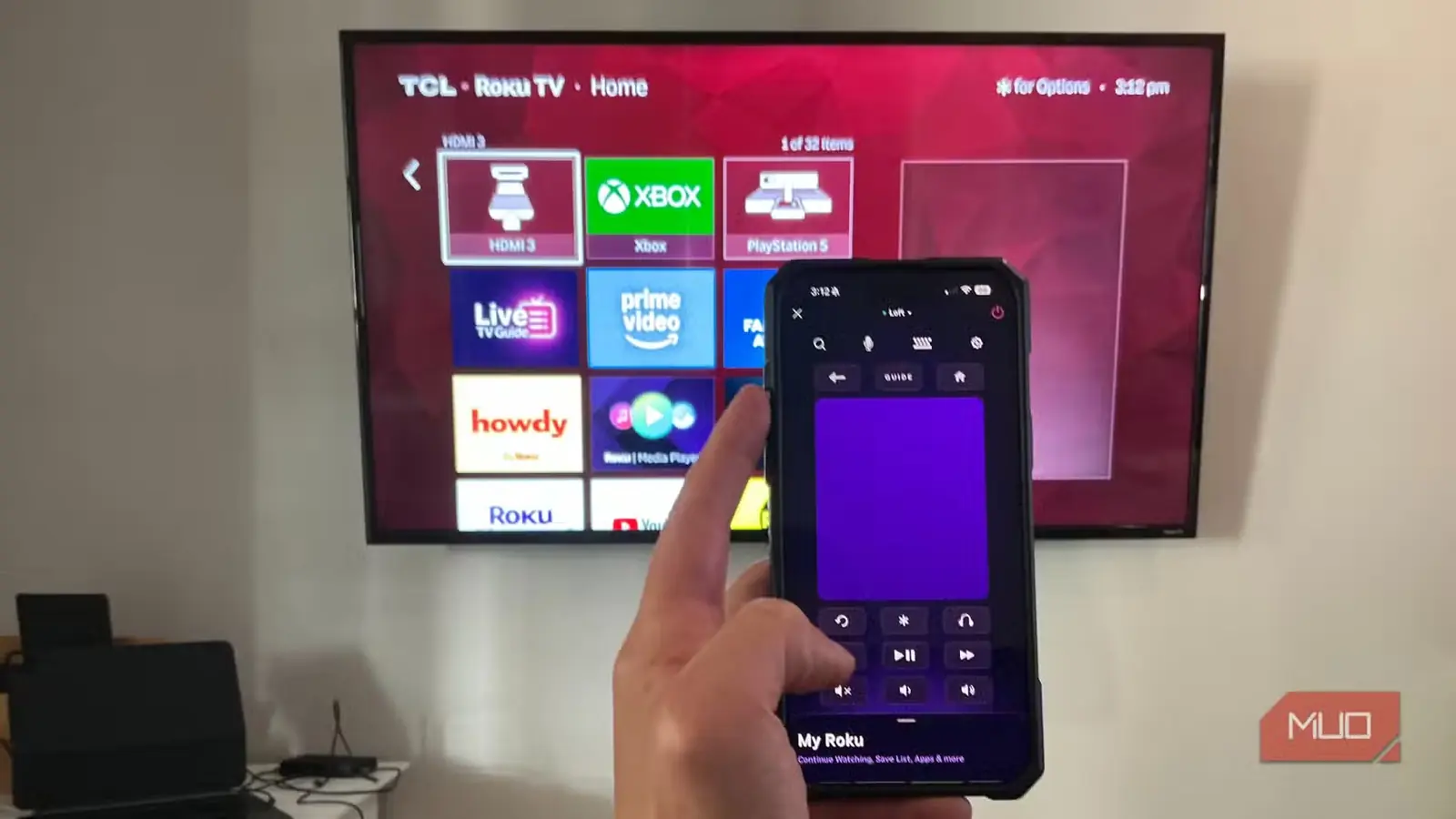 کنترل تلویزیون TCL Roku TV در پسزمینه با برنامهٔ Roku روی iPhone 16 Pro Max