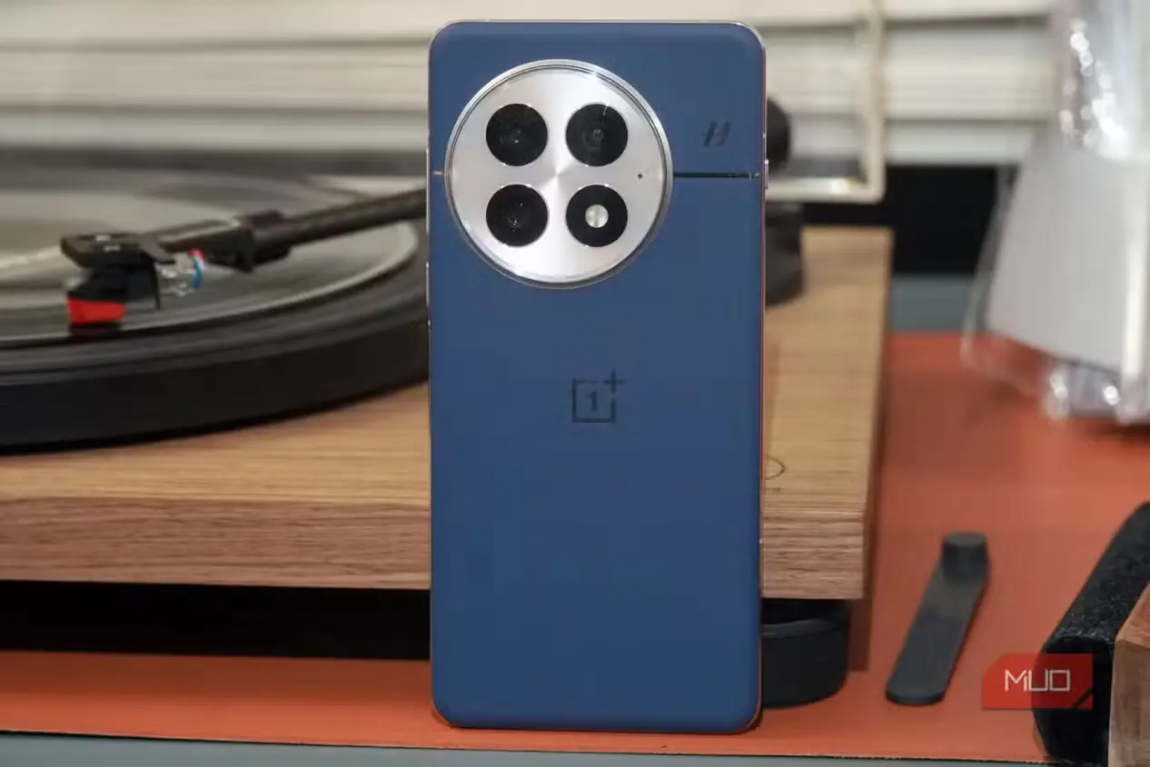 گوشی آبی OnePlus 13 تکیهداده به دستگاه پخش صفحه گرامافون