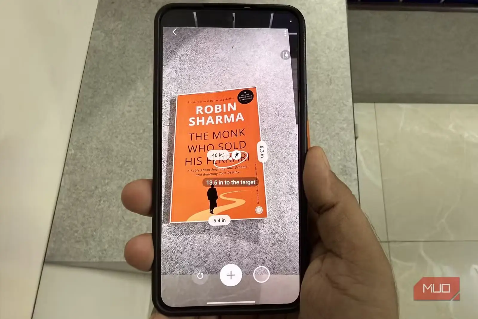 گوشی Samsung در حال اندازهگیری یک کتاب با برنامه Quick Measure